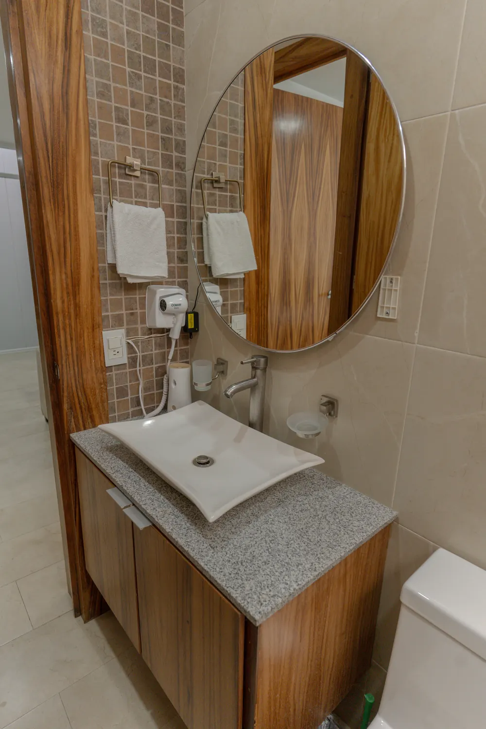 Lavabo con espejo redondo y secadora de cabello